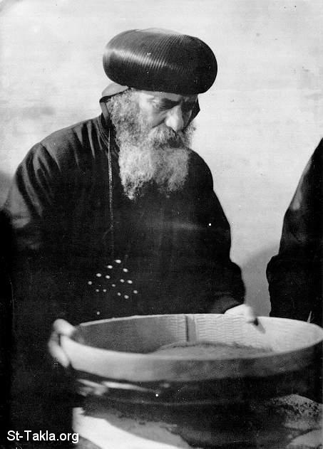 St-Takla.org Image: Pope Shenouda III while preparing the needed herbs for making the Mayroon Oil     :           