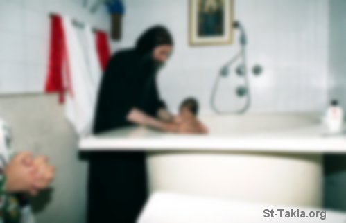 St-Takla.org Image: A Coptic Orthodox monk in Egypt baptizing an infant صورة في موقع الأنبا تكلا: راهب قبطي أرثوذكسي من الكنيسة القبطية الأرثوذكسية يقوم بتعميد طفل صغير