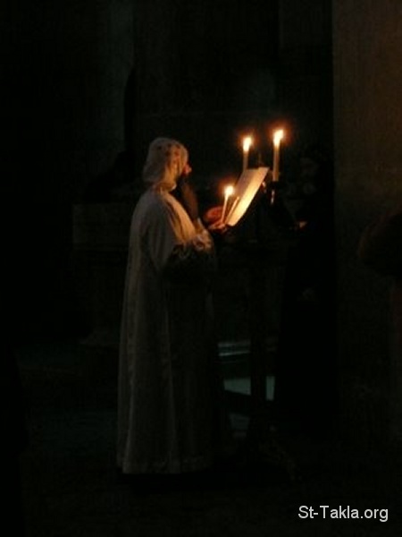 St-Takla.org Image: A Coptic Orthodox monk praying in Church with candle lights صورة في موقع الأنبا تكلا: راهب قبطي من الكنيسة القبطية الأرثوذكسية يصلي على أضواء الشموع